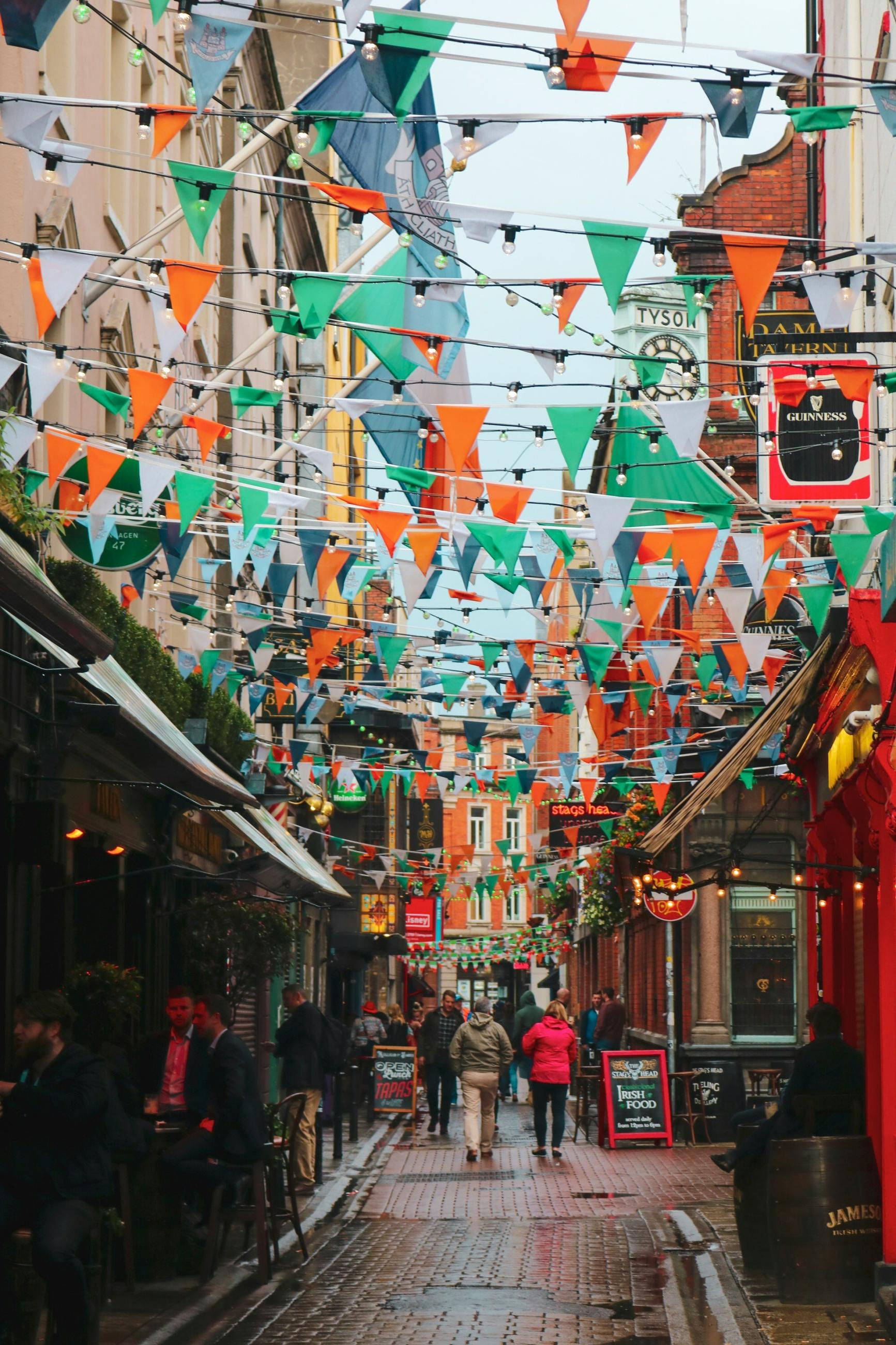 a charming alley way with orange and green triangle flags hanging above